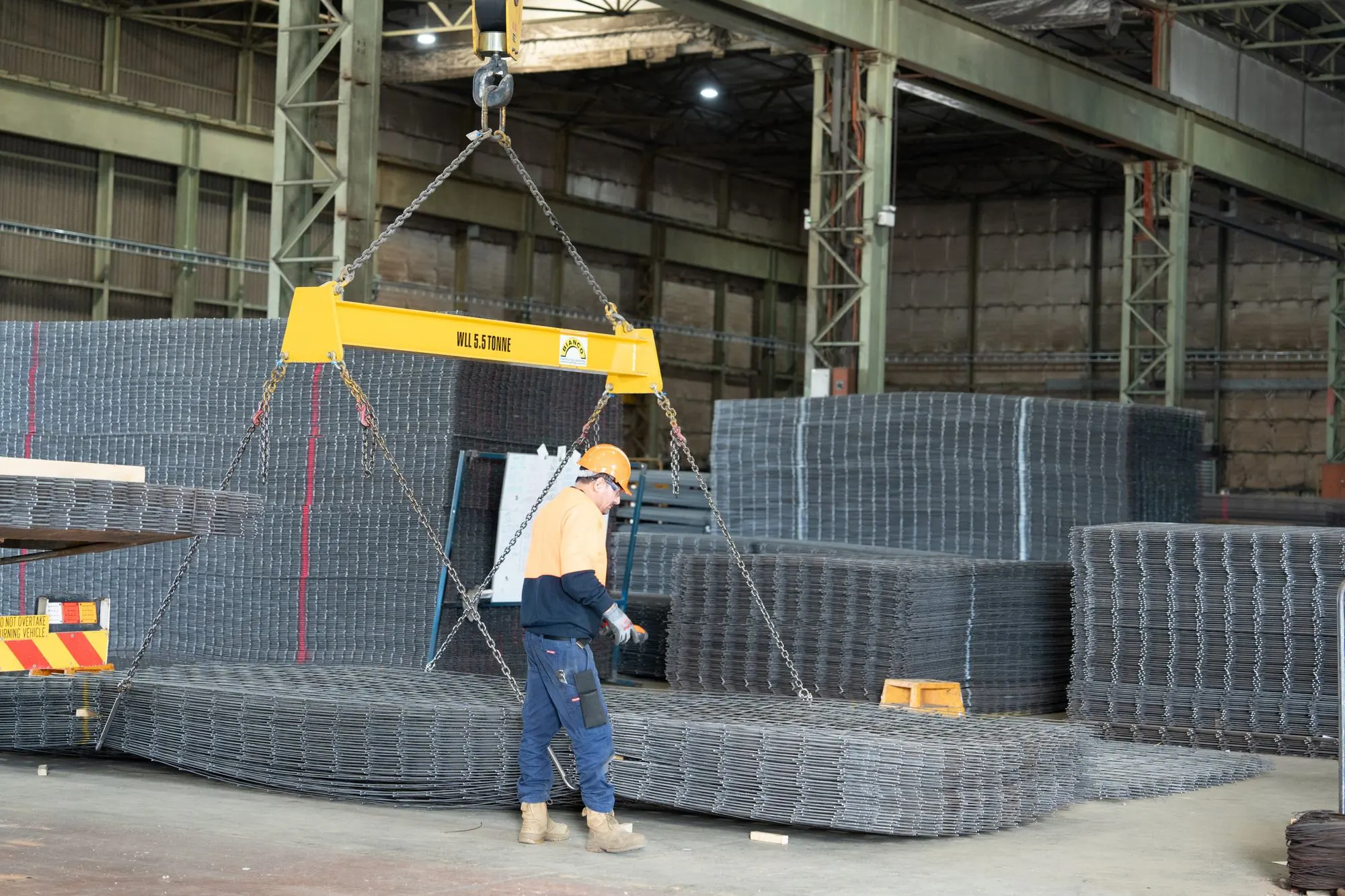 Bianco team member guiding a crane lift of reinforcing mesh in the factory