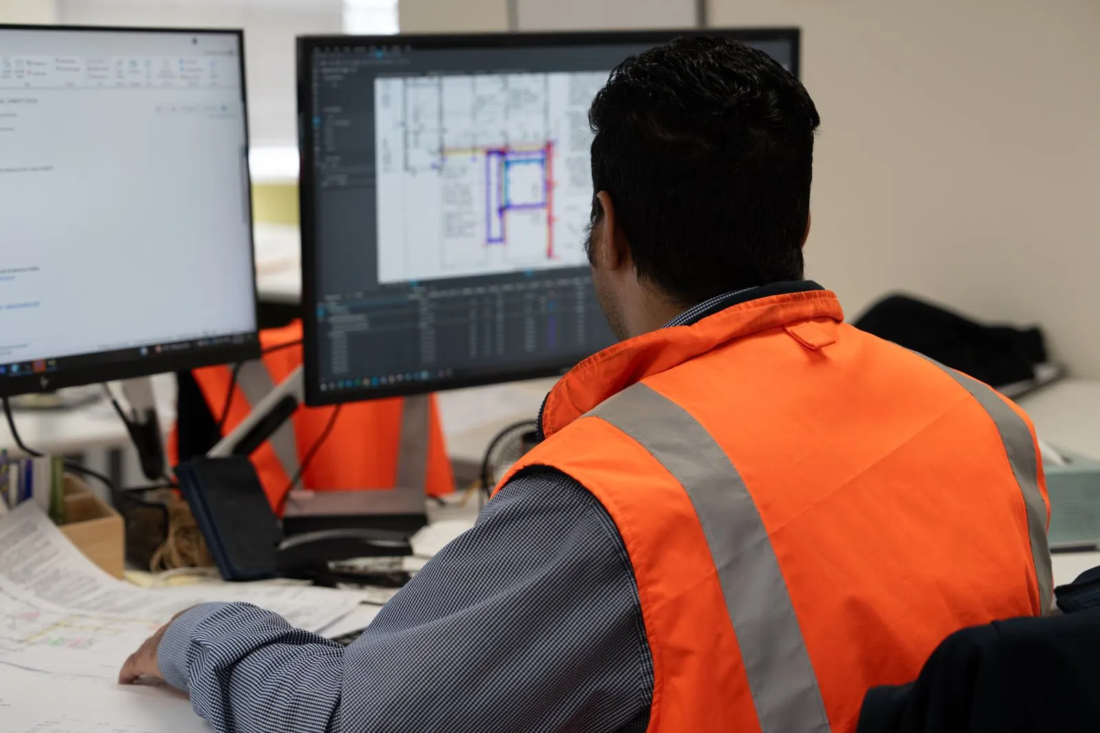 Team member reviewing a detailing drawing on two screens